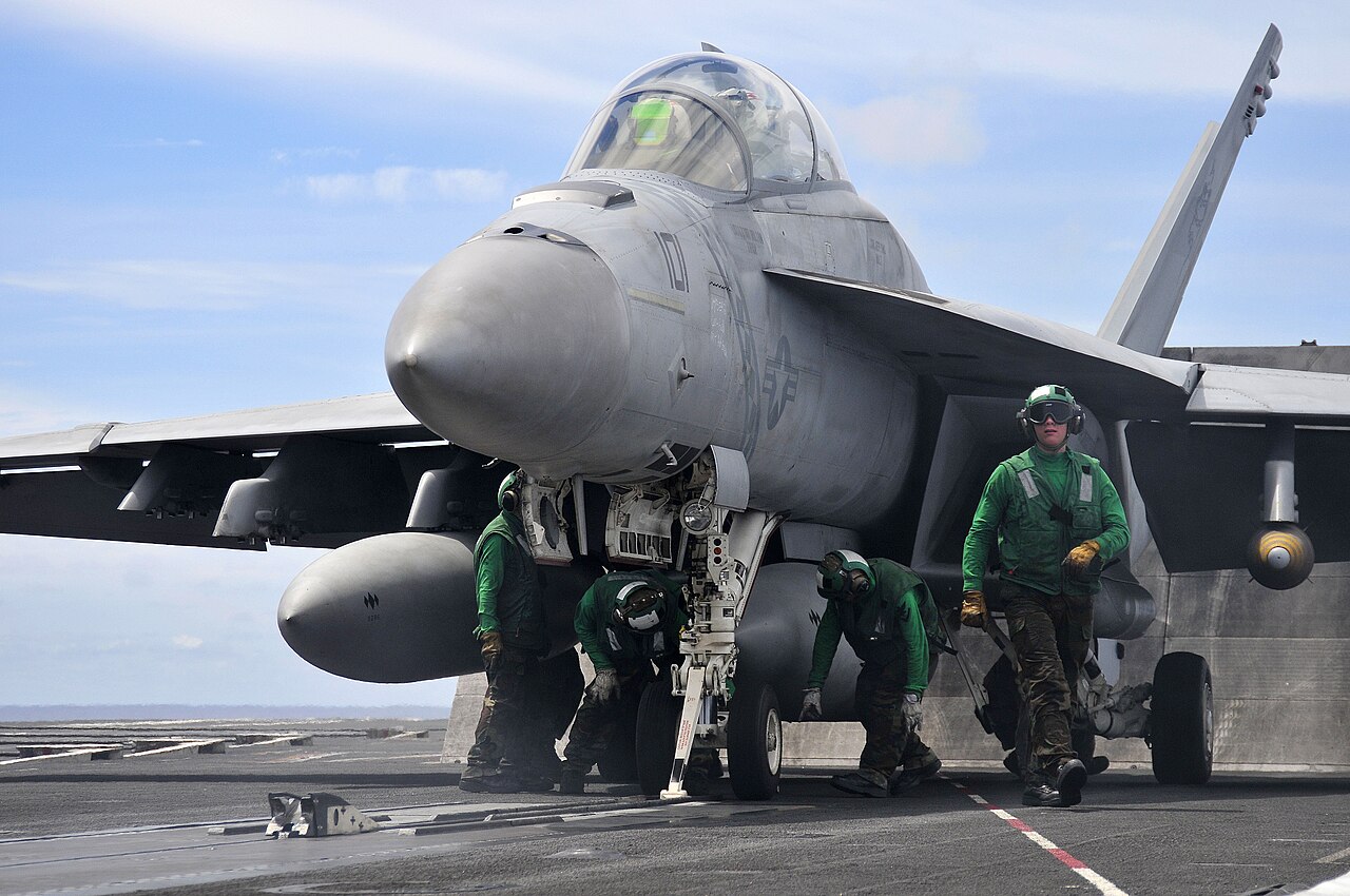 An F/A-18E Super Hornet launches from a carrier flight deck during operations.