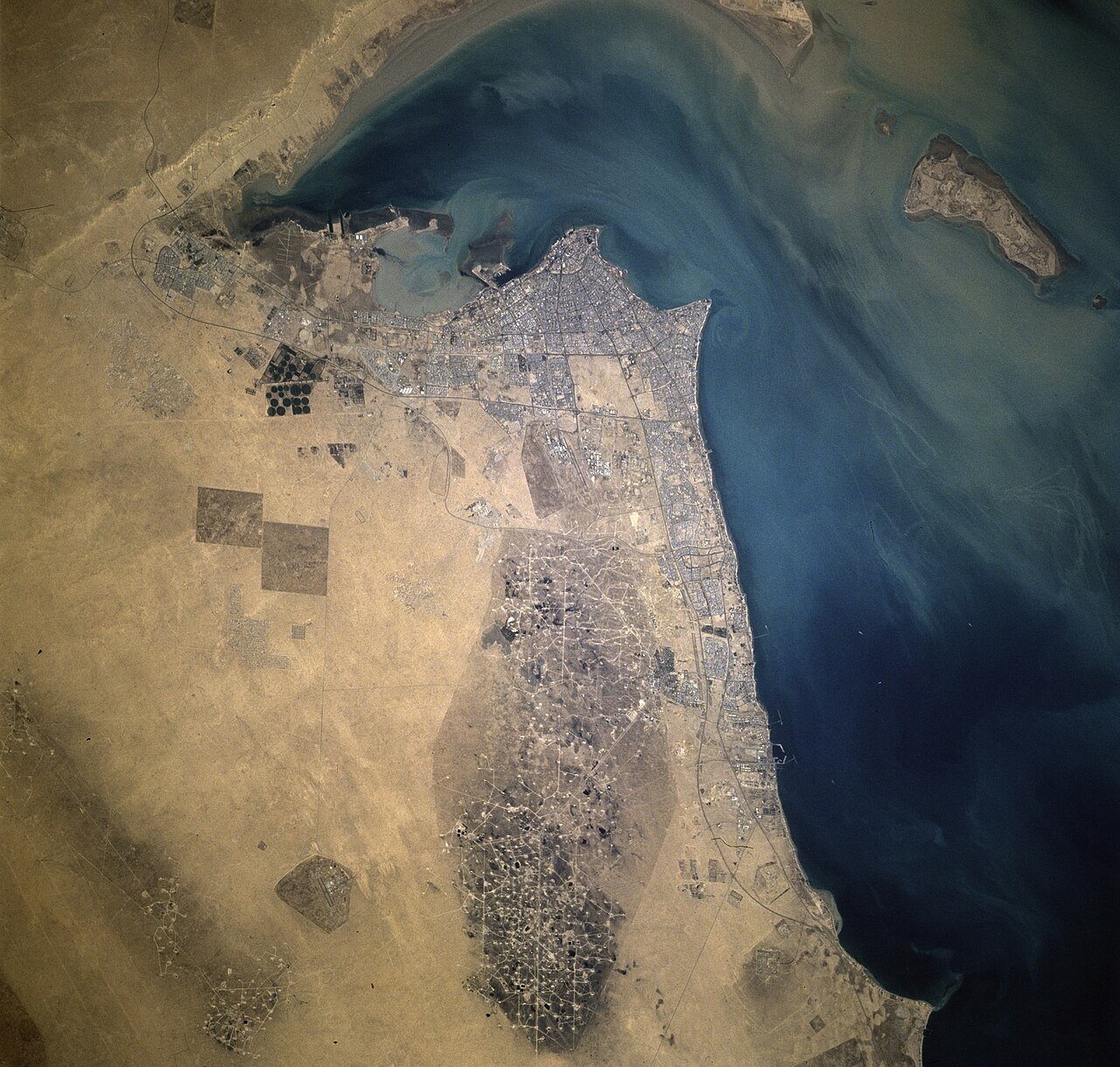 Satellite view of an oil field, showing the scale of major oil infrastructure.