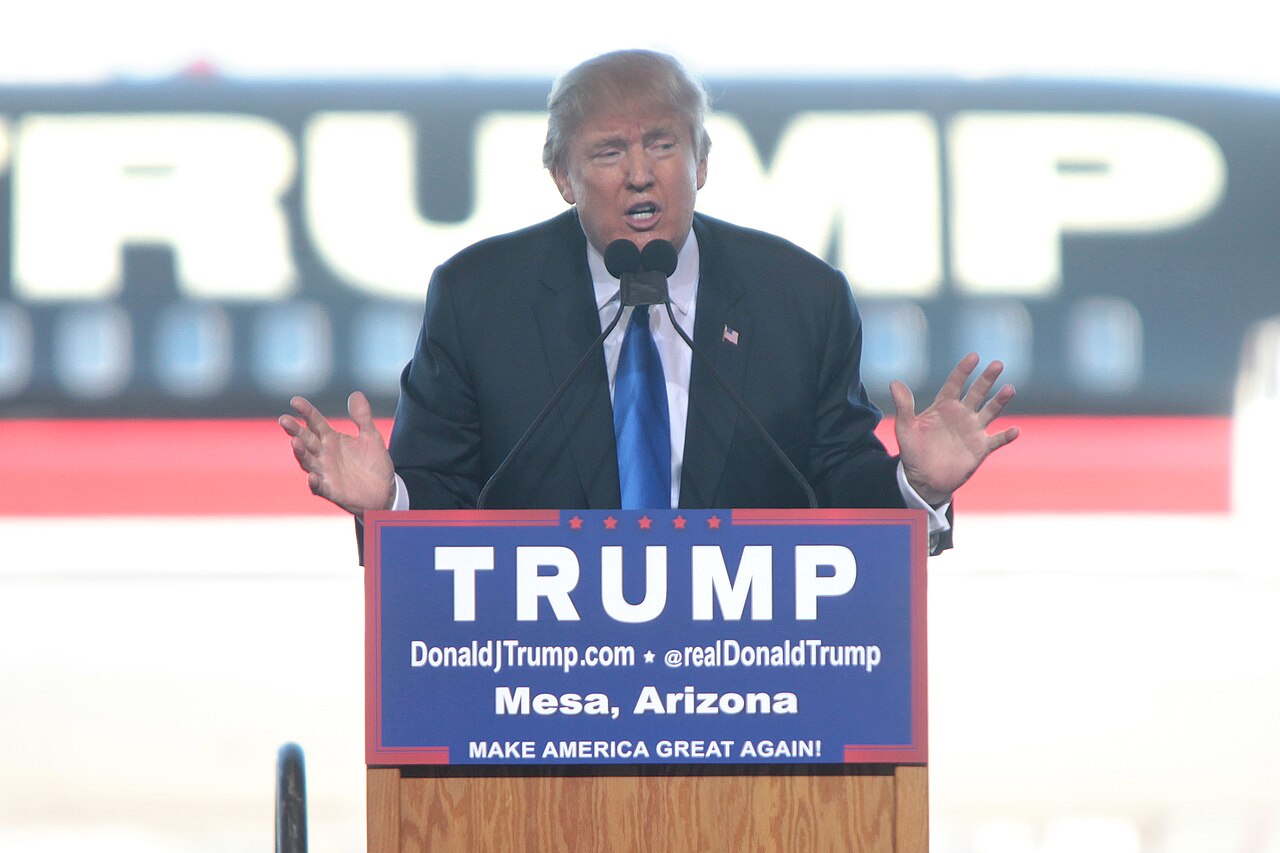 Donald Trump speaking with supporters at a hangar.