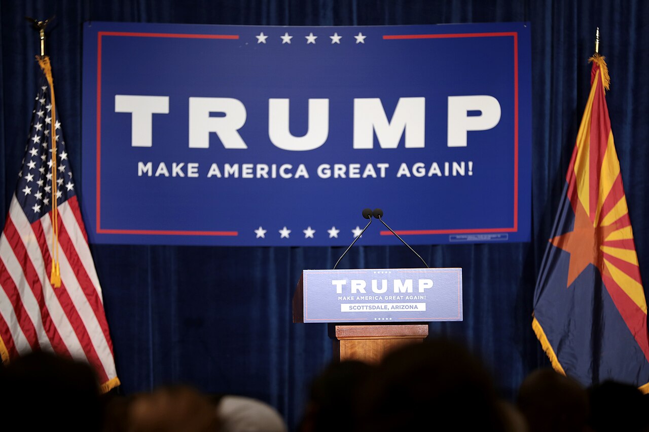 Donald Trump stands at a podium at a campaign rally.