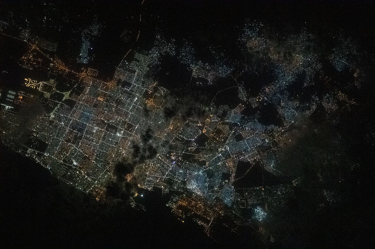 Contains modified NASA imagery of Jeddah, Saudi Arabia from the International Space Station, showing King Abdulaziz International Airport.