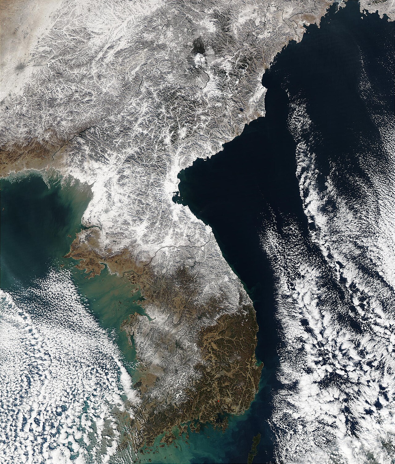Contains modified NASA Aqua MODIS satellite data showing North Korea and South Korea with snow cover in December 2002.