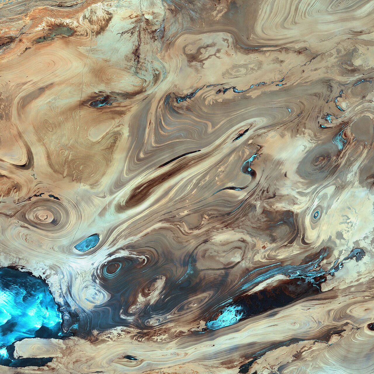 Satellite image of desert geological formations in Iran shaped by erosion.